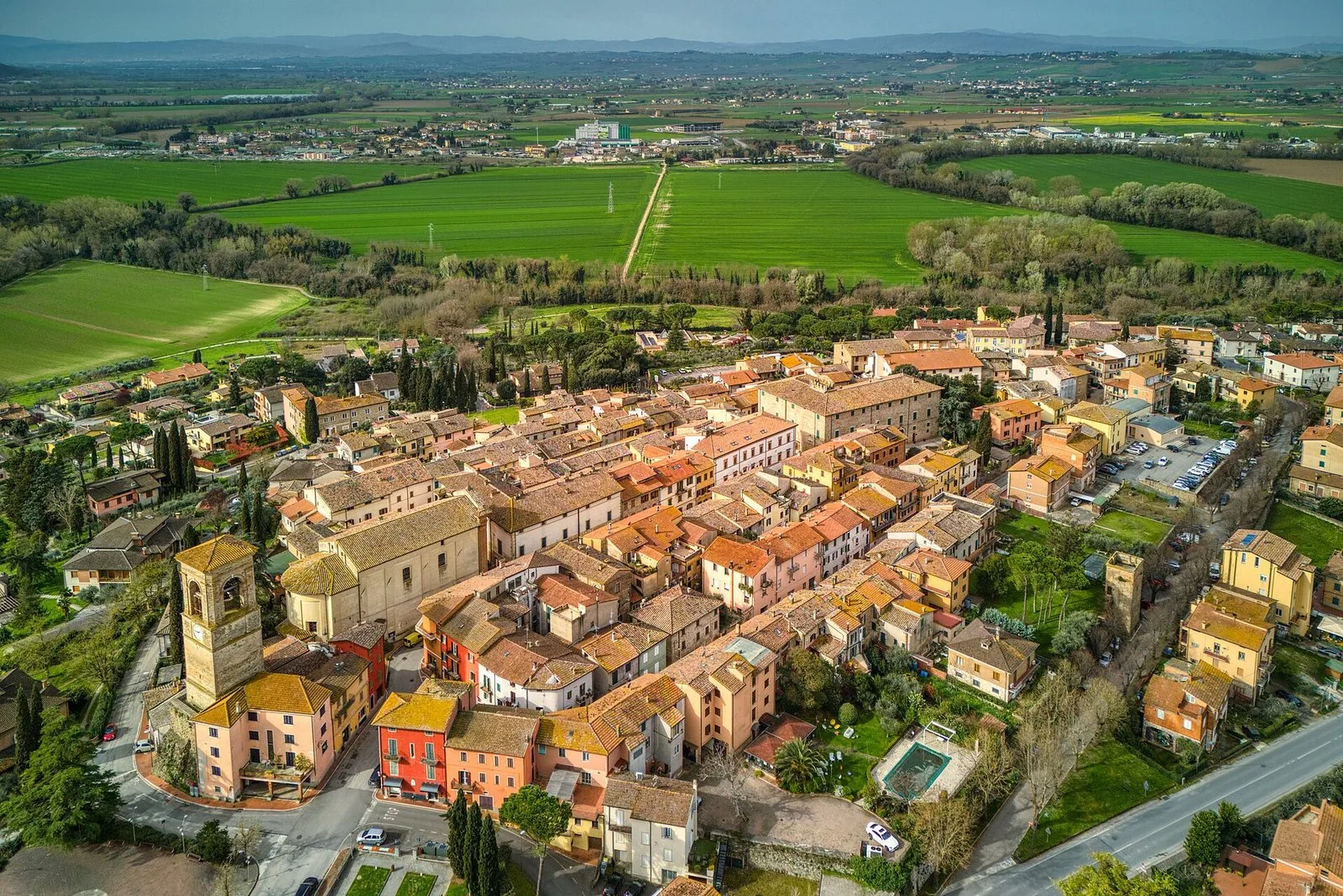 Il borgo di Torgiano visto dall'alto tra i campi verdi della valle del Tevere